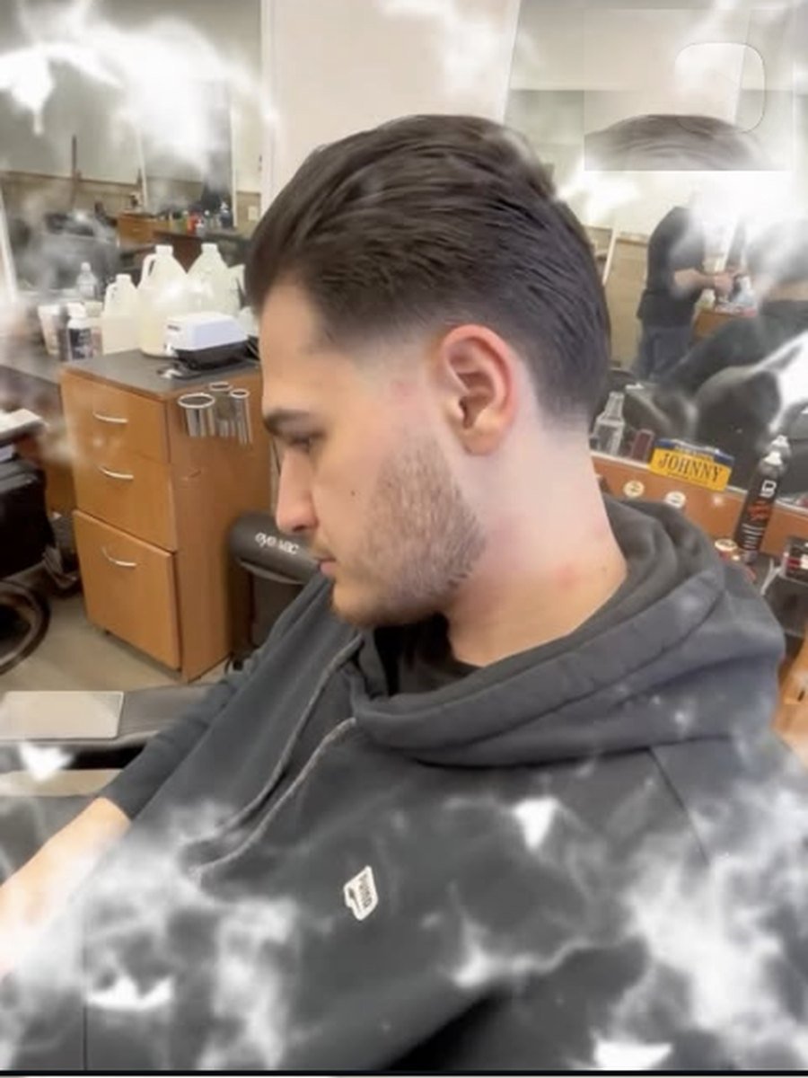 Longer layered cut blended into a low fade at Plaza Barber Shop West Hempstead