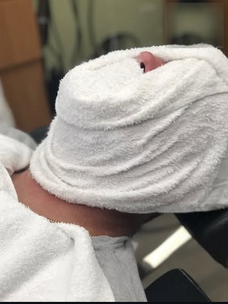 Hot towel wrapped and resting before a straight razor shave at Plaza Barber Shop West Hempstead